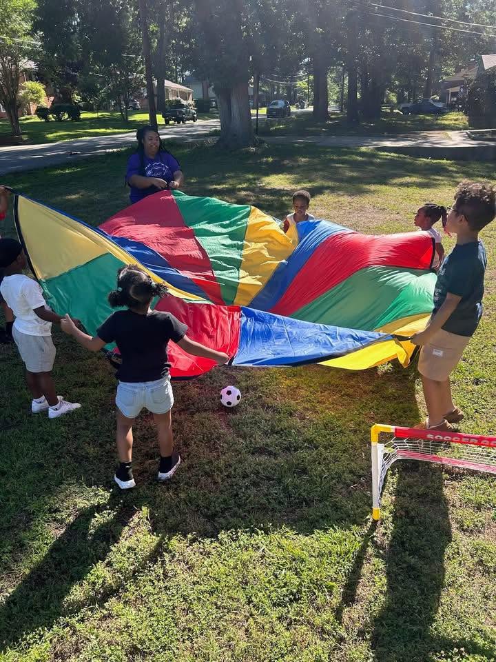 Students playing with a parachute outside